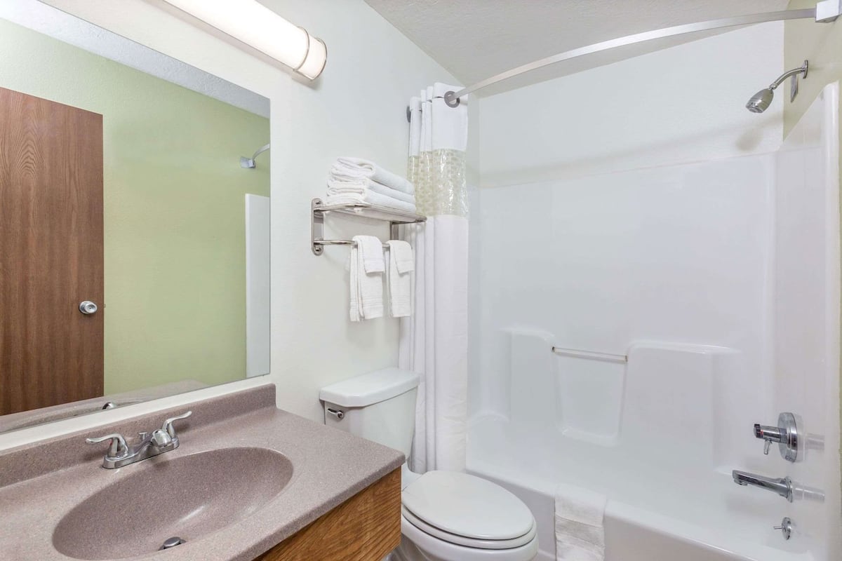 A bathroom with a sink, toilet, and shower.