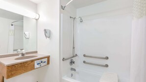 A modern bathroom with a sink, mirror, and shower area.