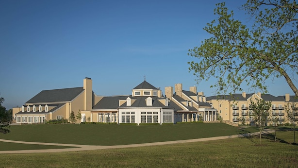 A large, multi-story building with a symmetrical facade, multiple chimneys, and a central entrance with columns. - Salamander Resort And Spa (Middleburg)