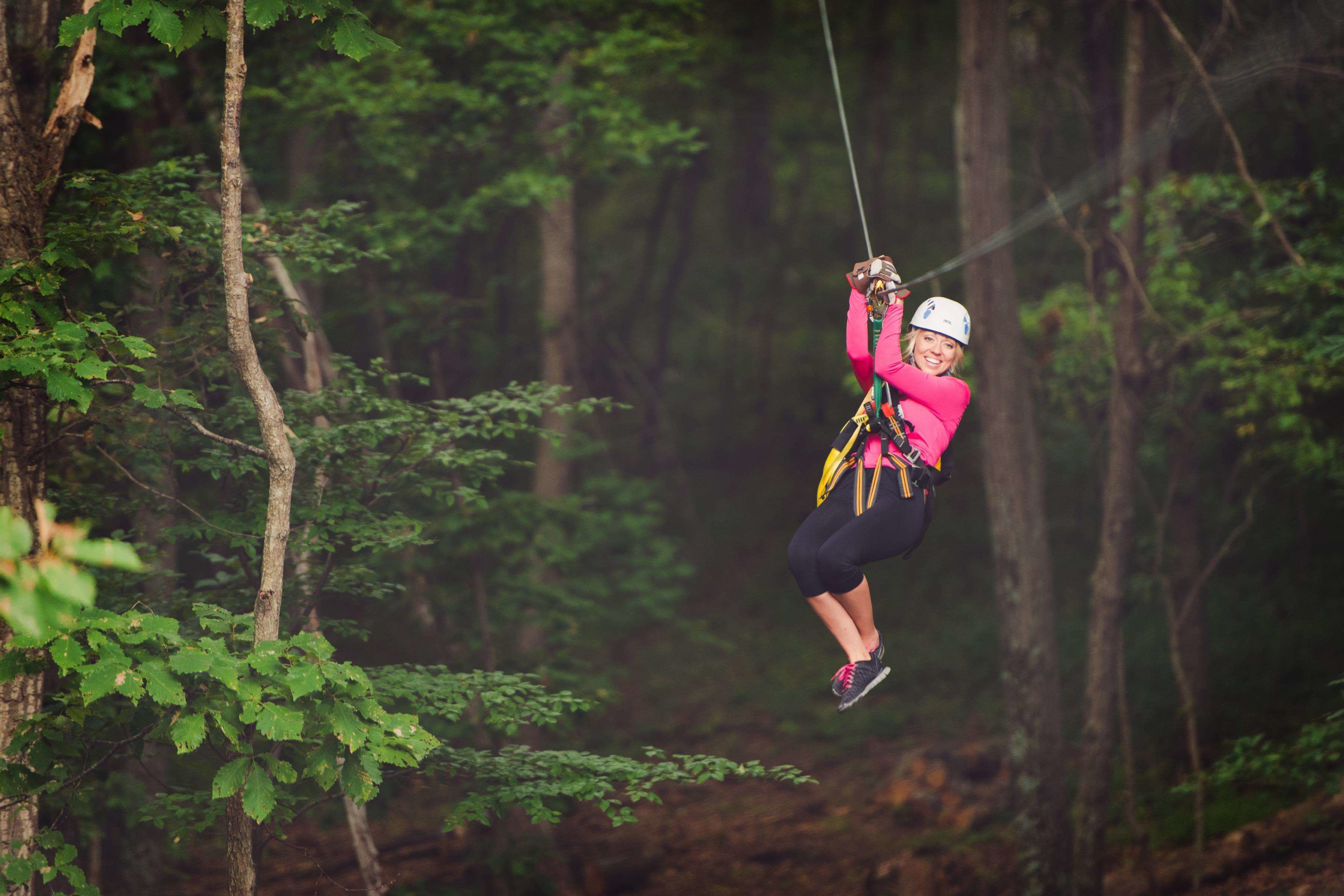 Una persona che vola su una zipline attraverso una foresta.