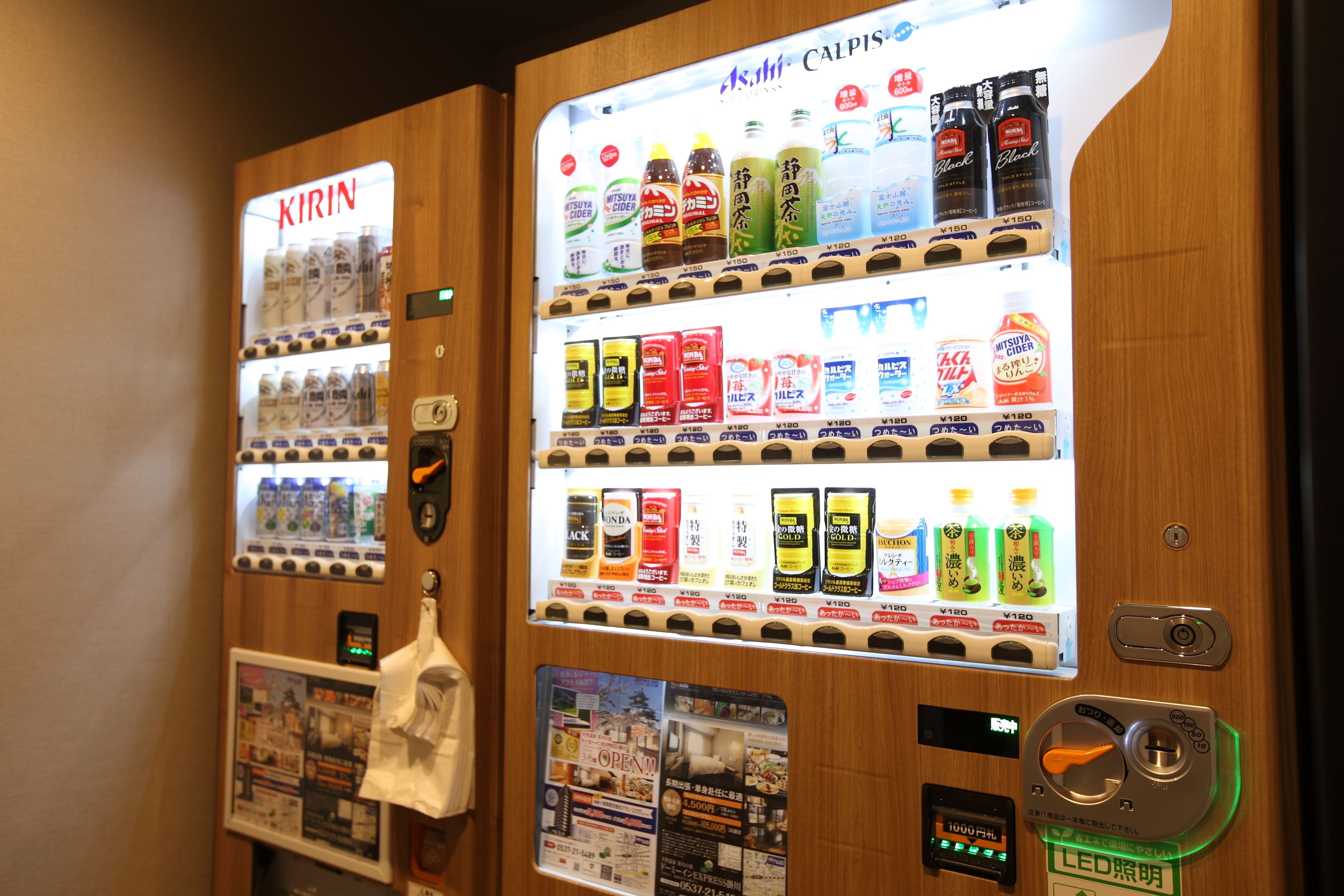 A vending machine with various beverages and snacks, a digital display, and a hanging towel.