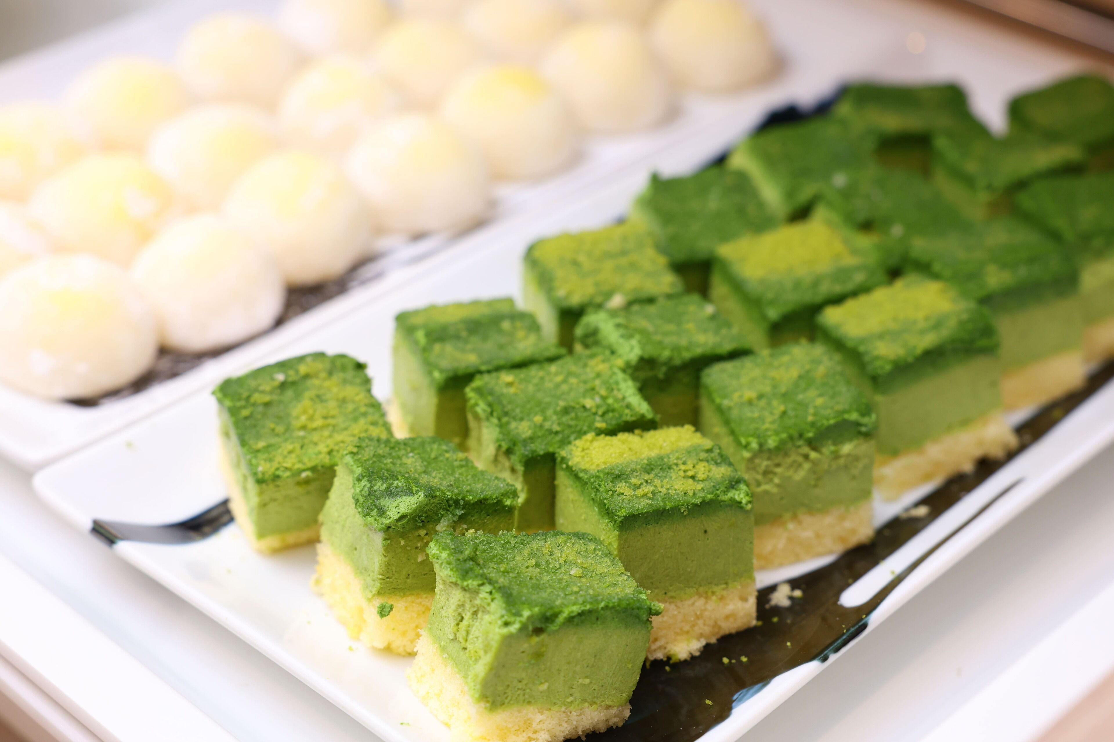 A dessert tray with green and white sweets.