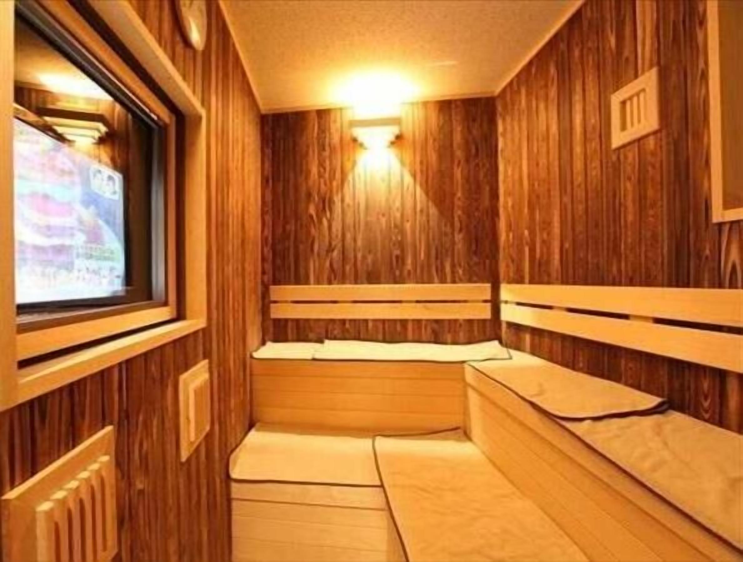 A sauna room with wooden walls and benches.