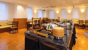 Un buffet avec plusieurs points de service, des chaises et des tables disposées dans une pièce spacieuse dotée de grandes fenêtres.