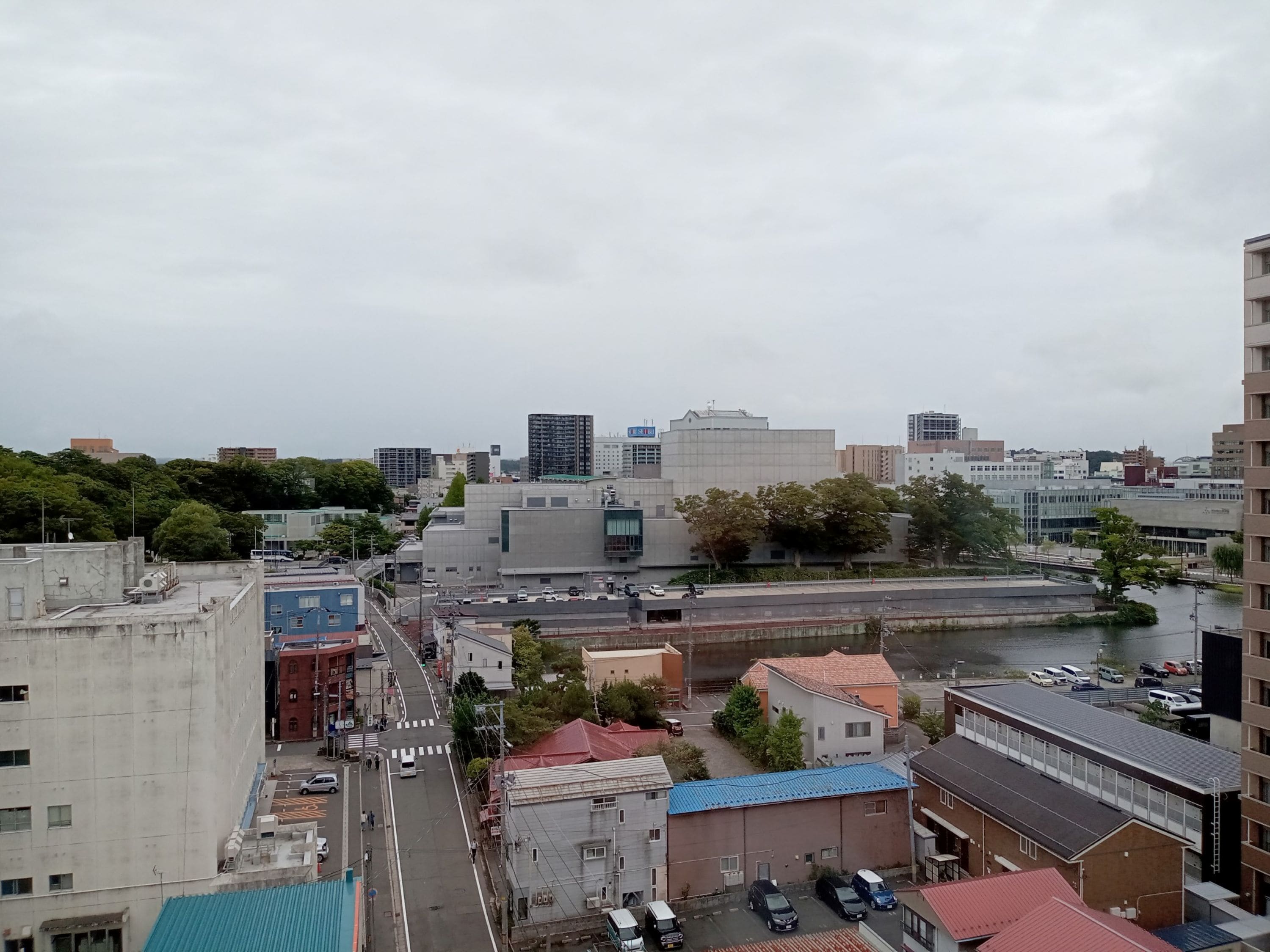 A cityscape with buildings, a river, and a clear sky.