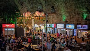 An indoor dining area with multiple seating arrangements and a variety of food stalls. - Okay 1 Villa (Siem Reap)
