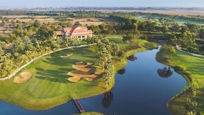 A golf course with a clubhouse, water features, and surrounding greenery. - Okay 1 Villa (Siem Reap)