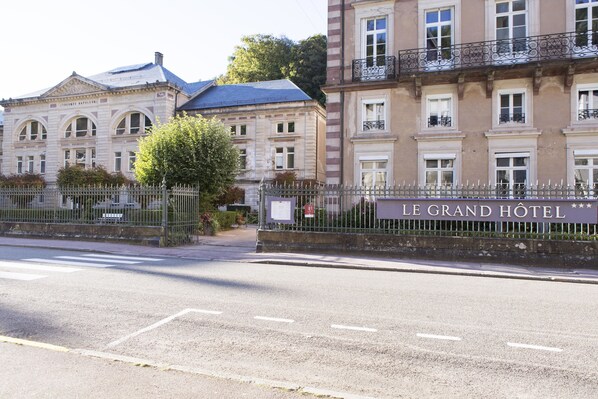 Un edificio histórico con un letrero que dice "LE GRAND HOTEL".
