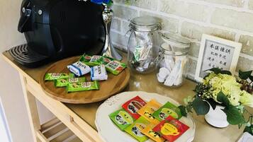 Un comptoir de cuisine avec une machine à café, des bocaux et des en-cas emballés.