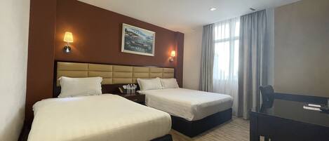Habitación de hotel con dos camas, un escritorio y un cuadro en la pared.
