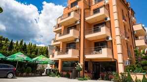 A multi-story hotel with balconies, outdoor seating, and a clear sky. - City Hotel Blagoevgrad (Blagoevgrad)