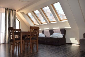 Un dormitorio tipo loft moderno con tragaluces, una zona de comedor y un sofá.