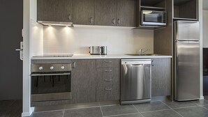 A modern kitchen with grey cabinetry, stainless steel appliances, and a dishwasher.