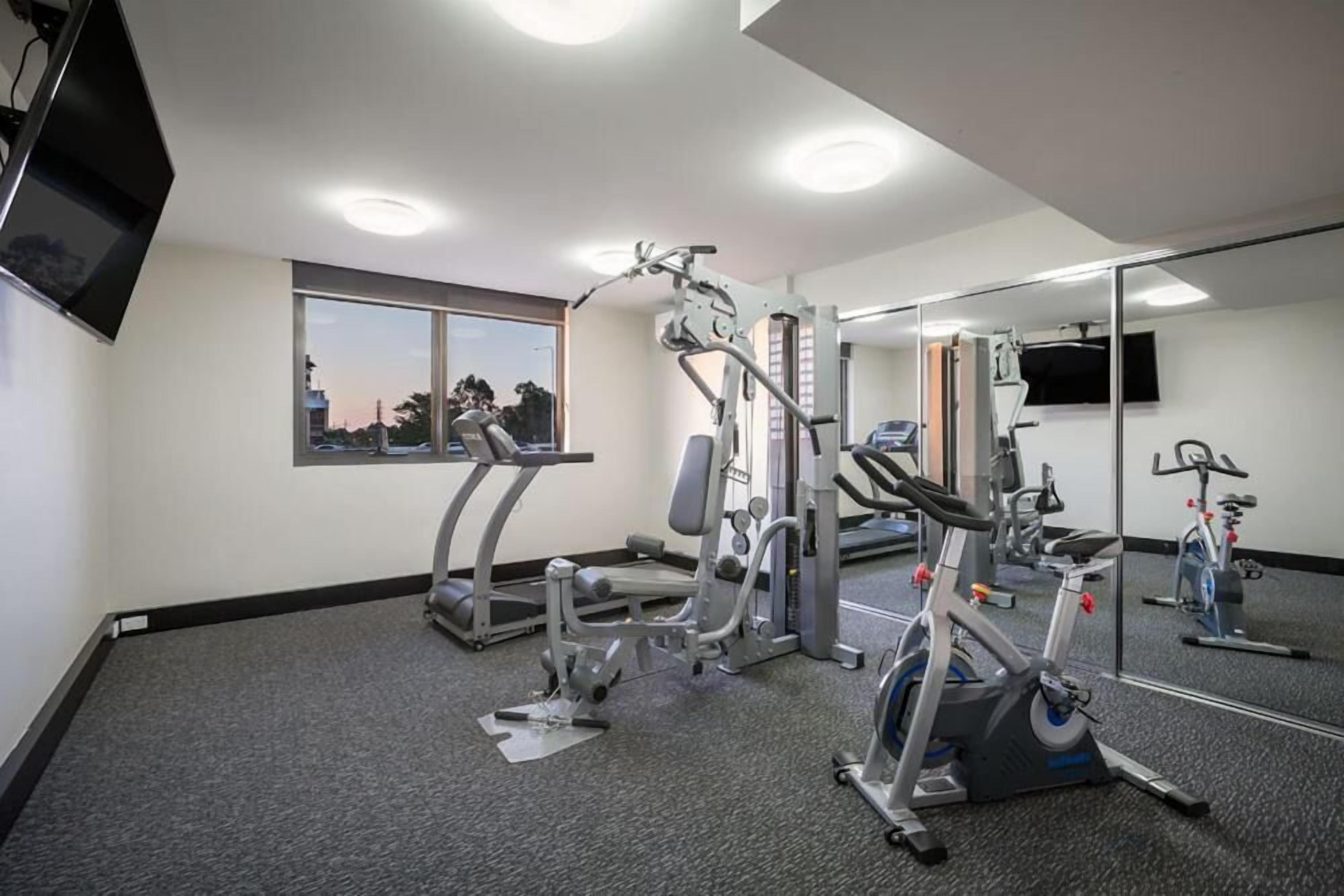 A gym with treadmills, weight machines, and an elliptical.
