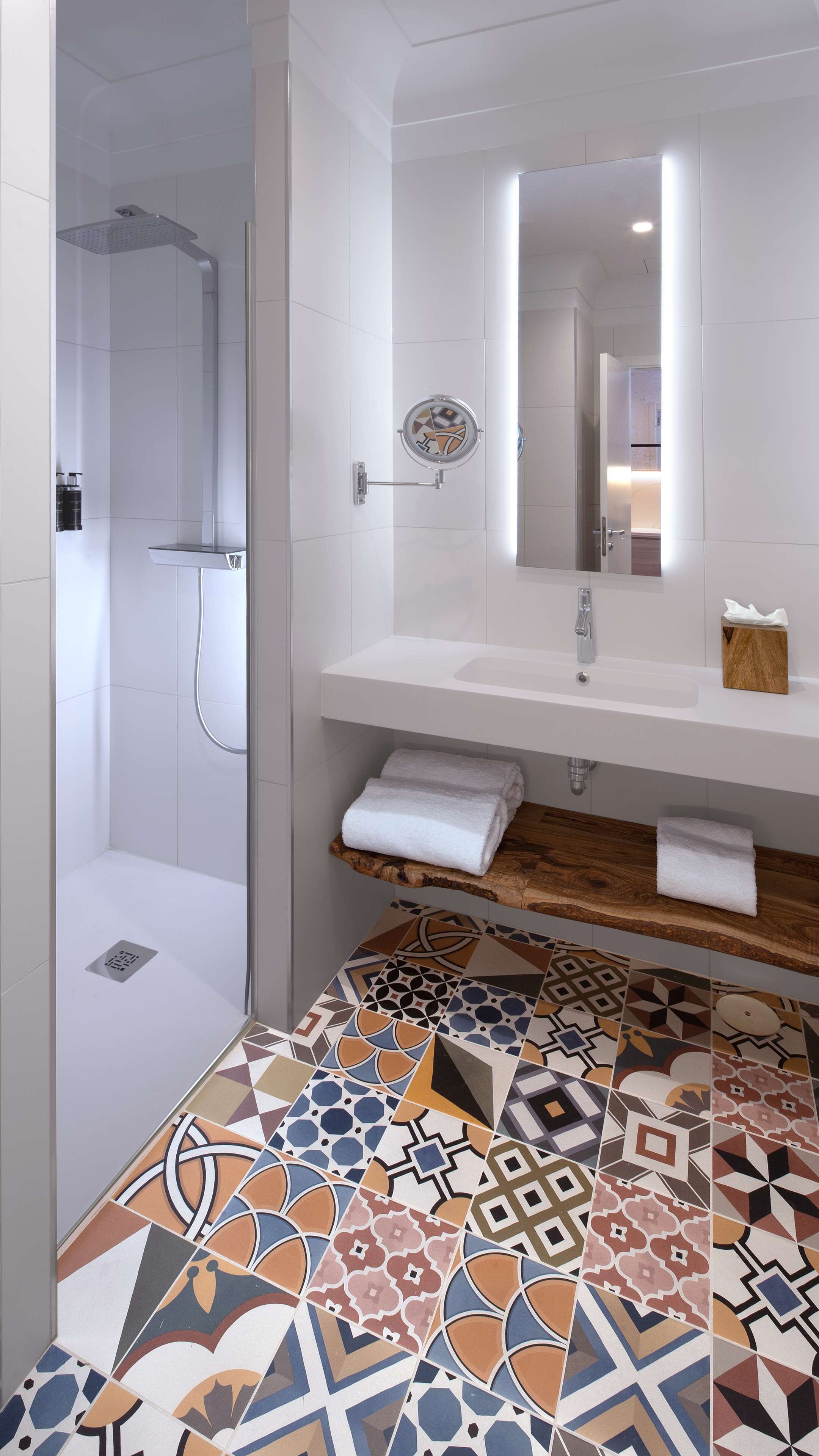 A modern bathroom with a shower, a sink, and a mirror.