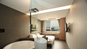 A modern bathroom with a large bathtub, a sink, and a mirror. - Hotel The Designers Hongdae (Seoul)