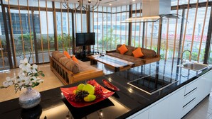 Cocina moderna con zona de comedor, ventanas amplias y televisor.