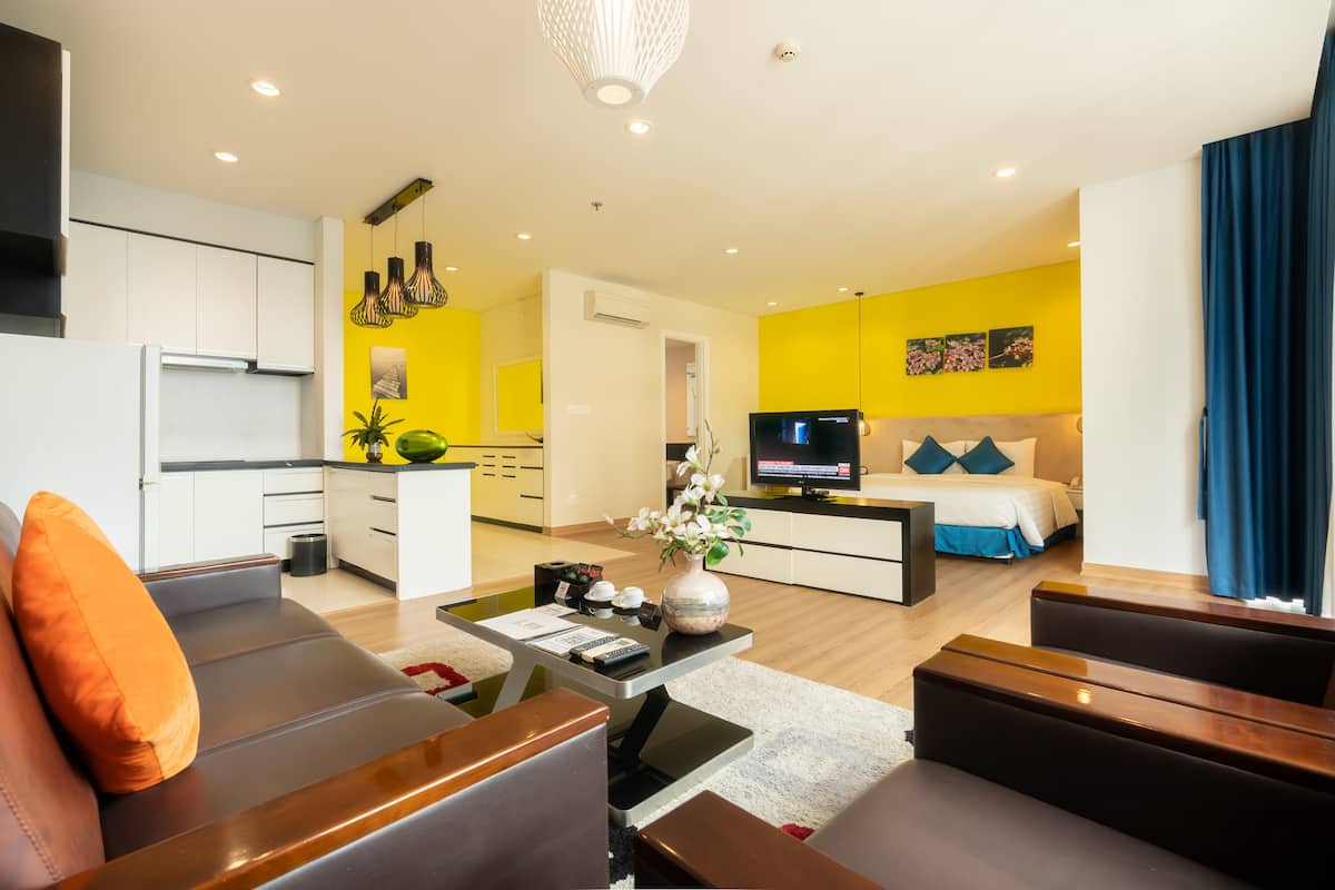 A modern living room with a sofa, coffee table, and a TV in the background.