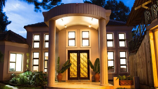 A house with a circular porch, large windows, and potted plants. - Zawadi House (Arusha)
