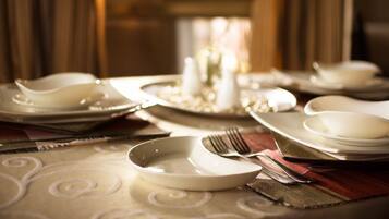 A dining table set with plates, bowls, a fork, and a knife.