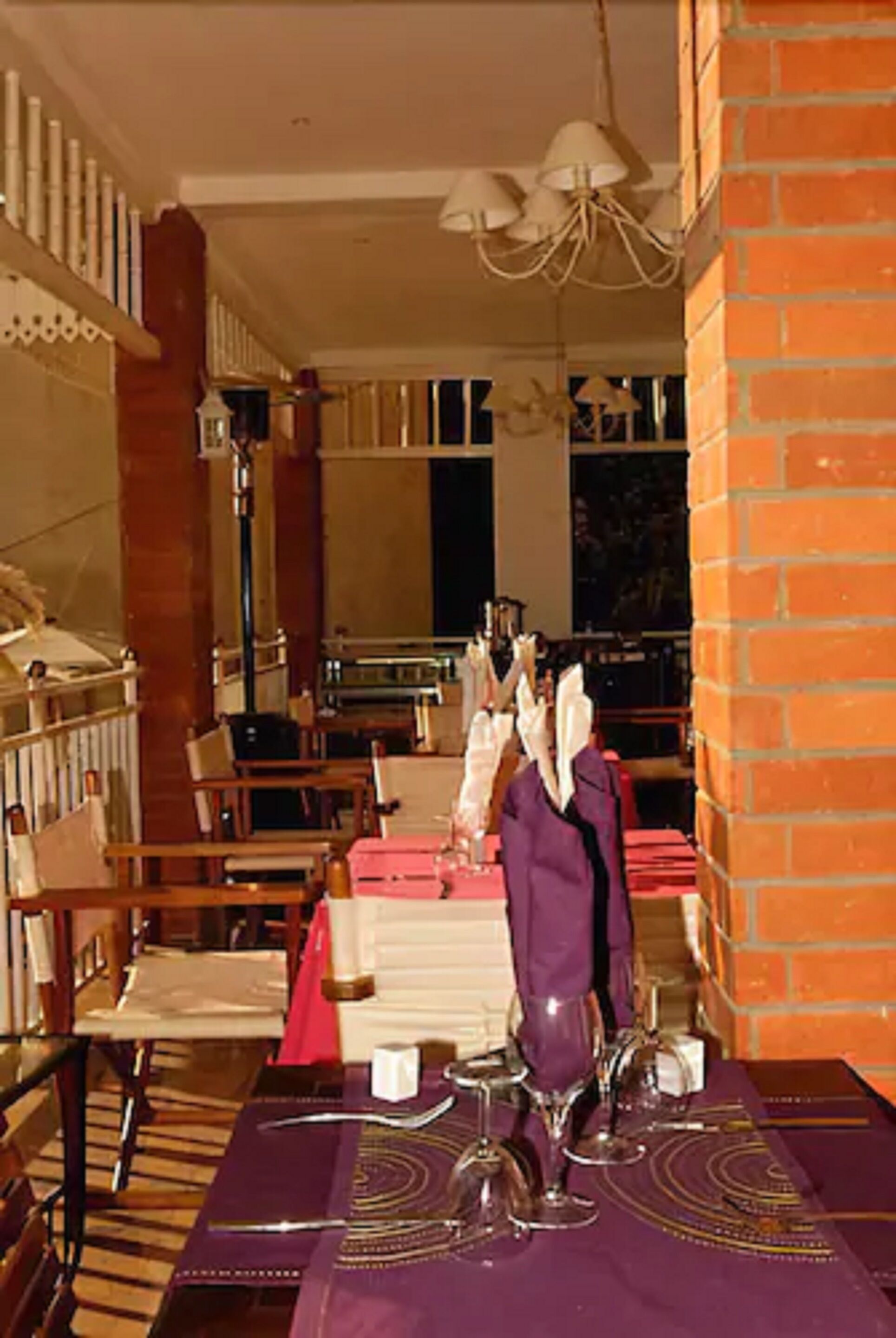 A dining area with a table set for a meal, chairs, and a chandelier.