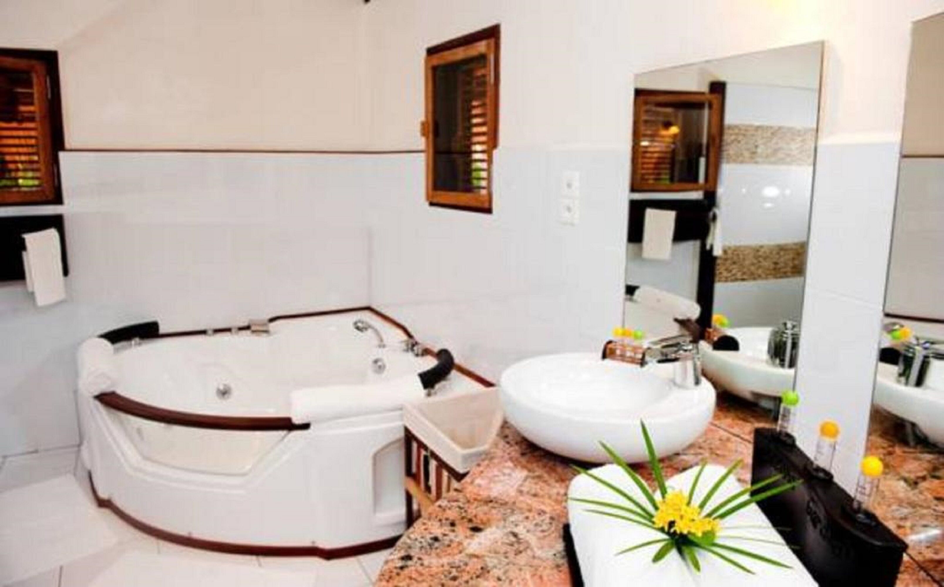 Un baño con una bañera independiente, un lavabo y un espejo grande.