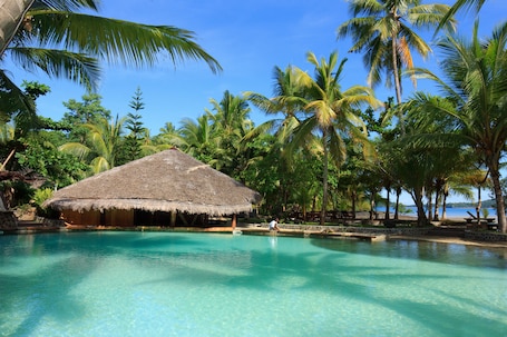 Una piscina al aire libre, sombrillas, sillones reclinables de piscina. Ravintsara Wellness Hotel