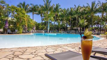 Una piscina al aire libre, sillones reclinables de piscina