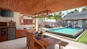 Eine moderne Küche mit Essbereich, Pool und einem separaten Gästehaus.