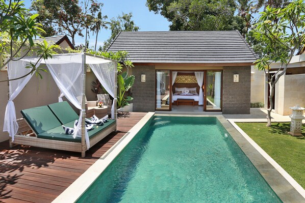 A private villa with a swimming pool, a covered outdoor seating area, and a bedroom with a view of the pool.