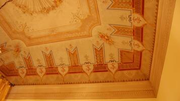 A ceiling with intricate floral and geometric patterns, including star and heart motifs.