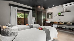 A modern spa room with two beds, a large mirror, a sink, and a window with curtains. - Villa Buena Onda (Sardinal)