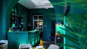 Una zona de bar con una decoración azul turquesa, taburetes y una barra con un letrero de neón.
