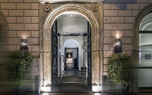 A grand entrance with a stone archway, a clock, and a sign indicating the hotel name.