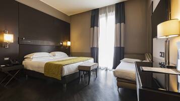A hotel room with a large bed, bedside tables, a desk, and a chair.