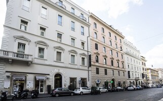 A row of historic buildings with a cafe and a pharmacy on the ground floor.
