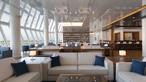 Une bibliothèque moderne dotée d’un espace de lecture central, de rayonnages et d’un bar.