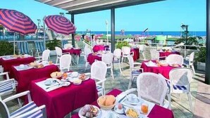 Un área de comedor al aire libre con mesas dispuestas para el desayuno, con vistas a un paisaje.