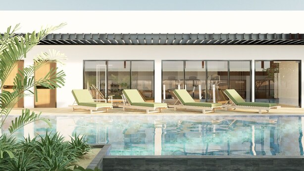 Un área de piscina moderna con sillones de descanso y una vista despejada del interior a través de grandes puertas de vidrio.