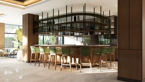 Un moderno bar con una estructura de madera curvada, sillas tapizadas en verde y un amplio ventanal que proporciona luz natural.