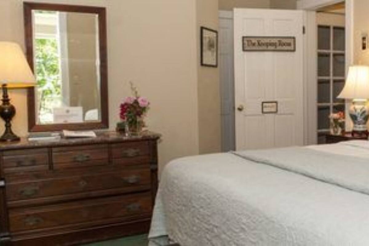 A bedroom with a bed, dresser, and a door labeled "The Keeping Room".