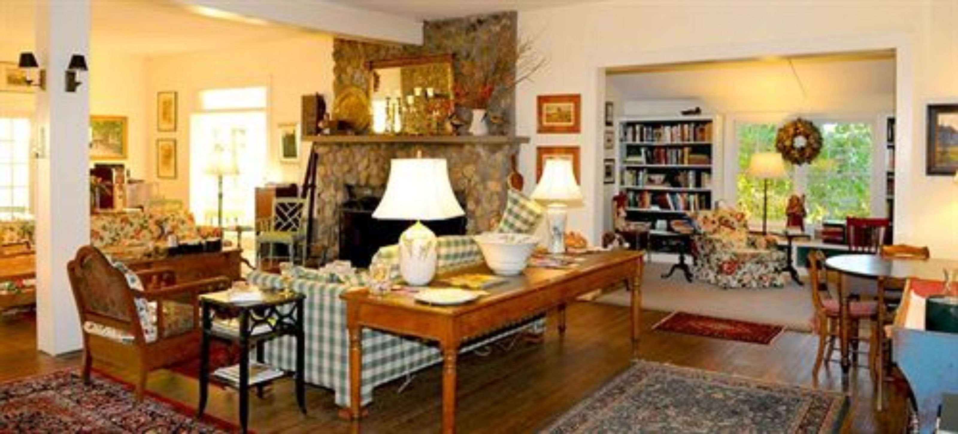 A cozy living room with a fireplace, a bookshelf, and a dining area.