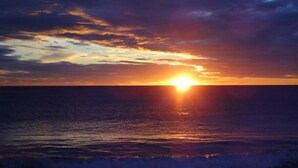Un atardecer sobre el océano con un horizonte despejado.