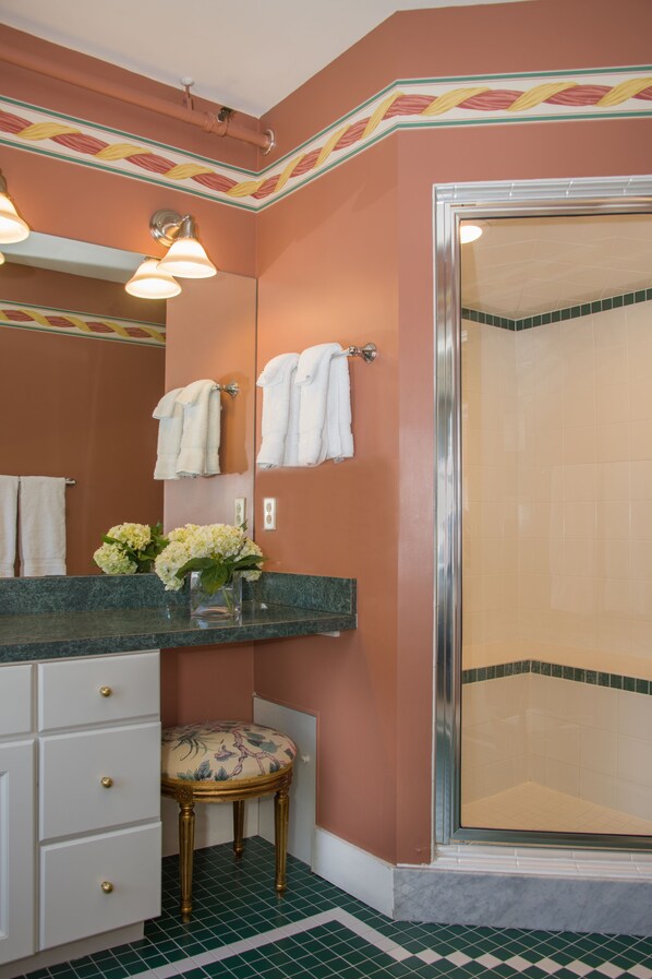 A bathroom with a vanity, a shower, and a toilet.