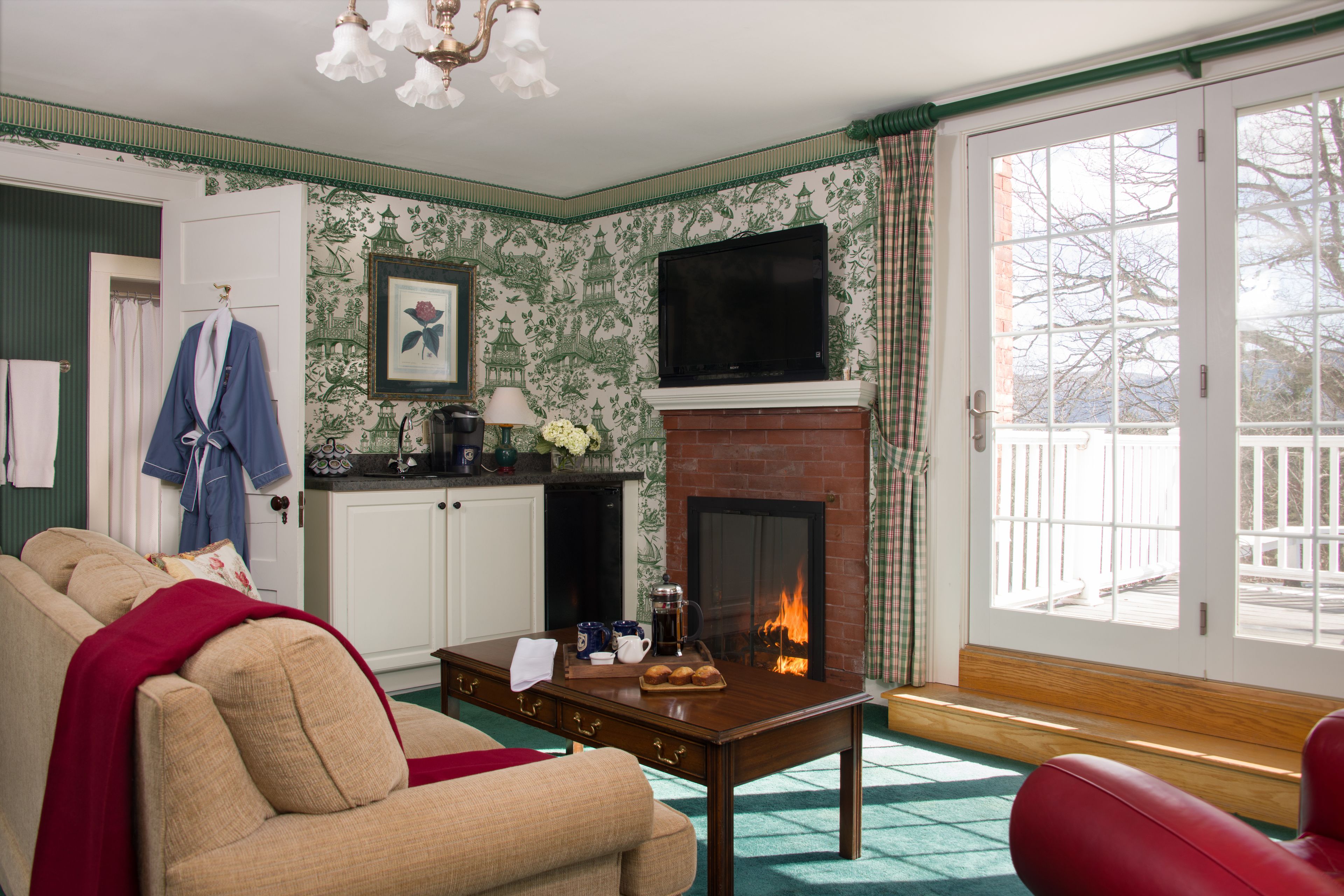 A living room with a fireplace, a sofa, a coffee table, and a television.