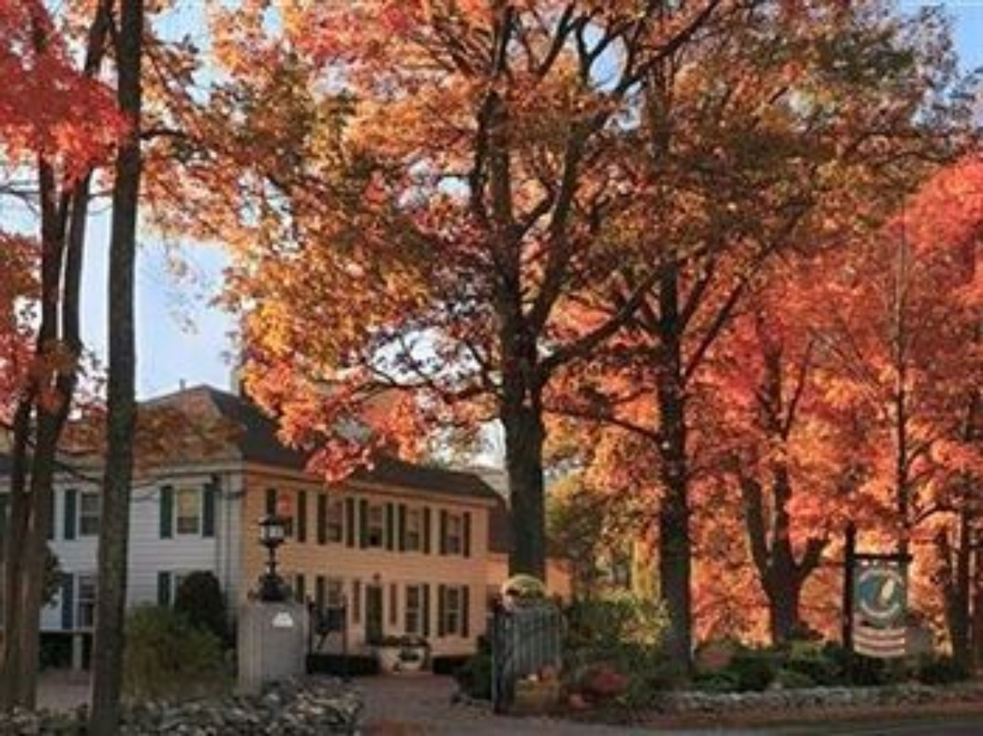 A building with a traditional architectural style, surrounded by trees with autumn foliage.