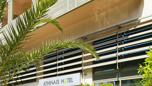 A hotel with a sign reading "ATHINAIS HOTEL" and a clear pool with a rock in the center. - Athinais Hotel (Athens)