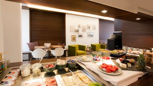 A buffet setup with various food items and a seating area with chairs and a sofa. - Stern am Rathaus (Cologne)