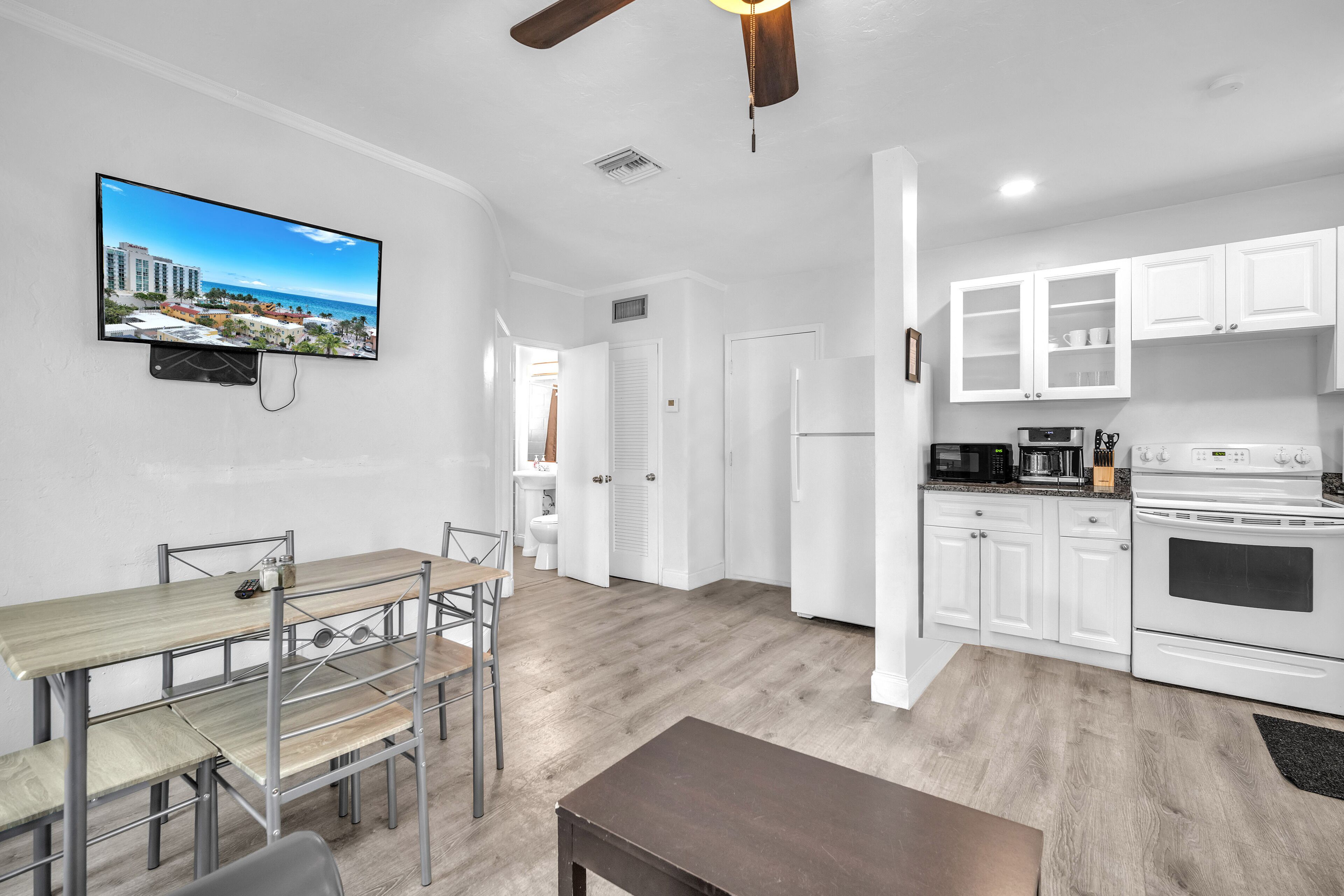 A modern kitchen with white cabinets, a built-in oven, and a microwave.