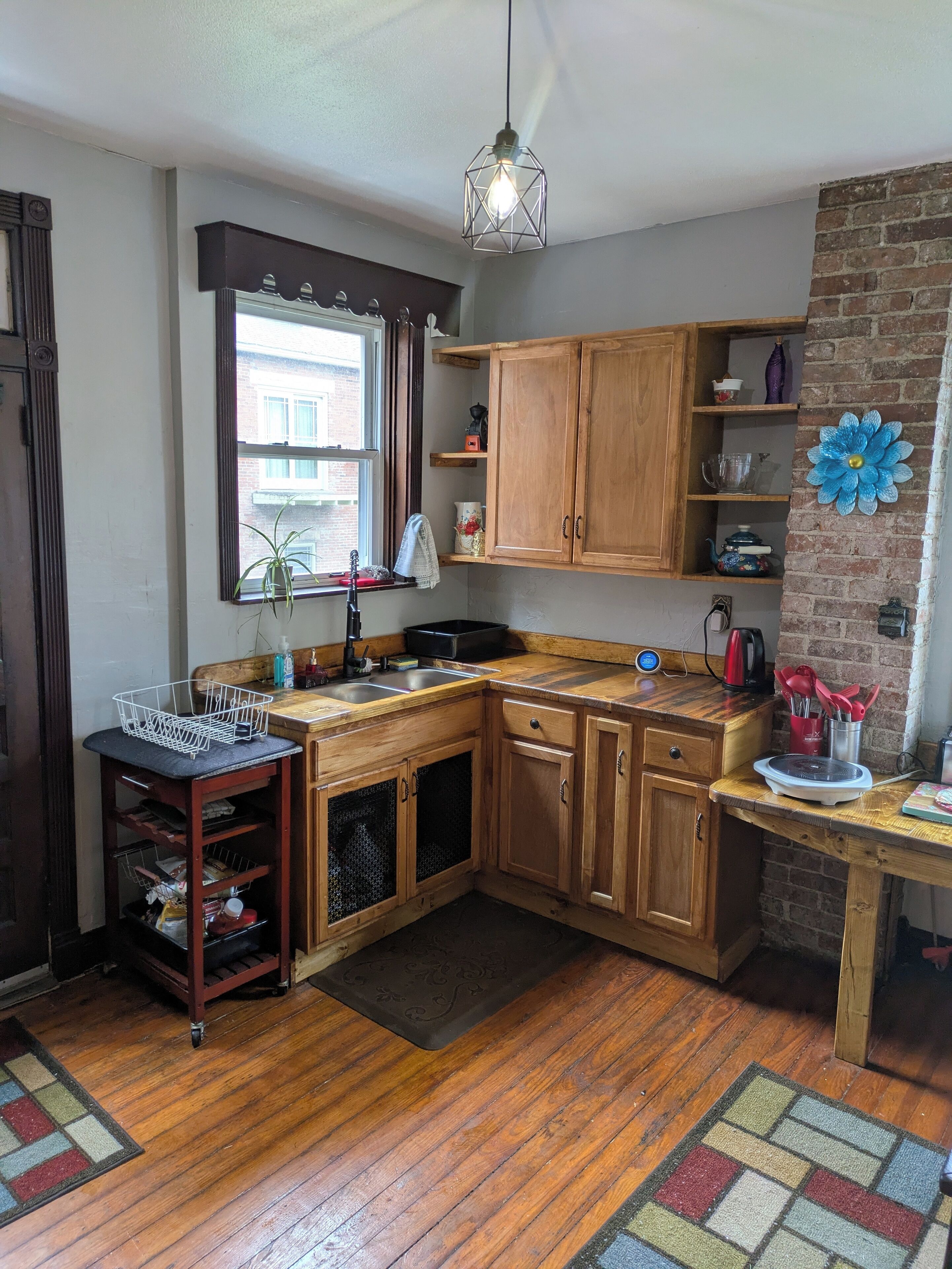 A compact kitchen with wooden cabinets, a sink, and a window.